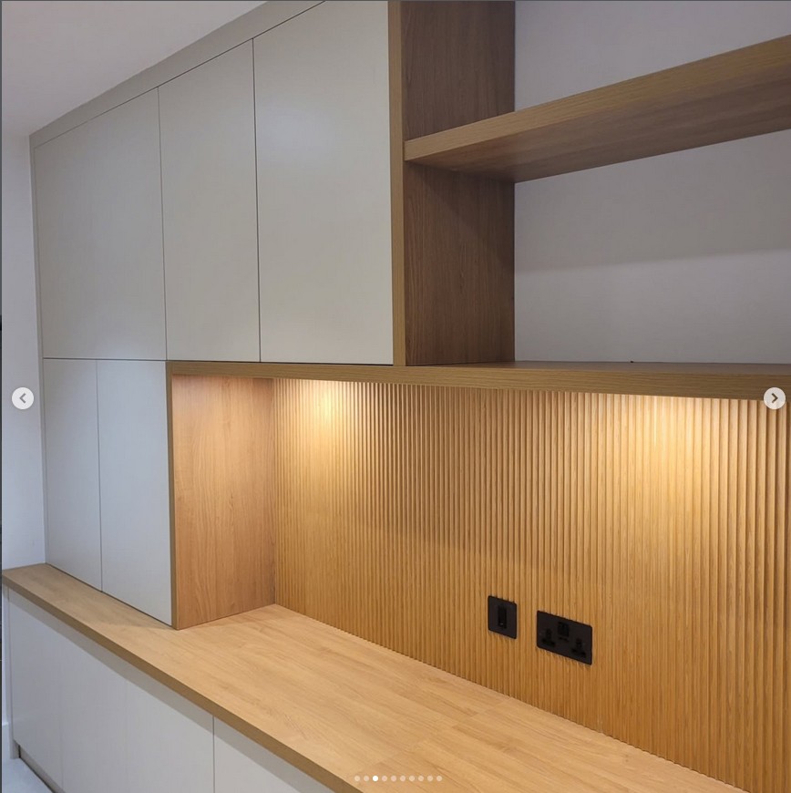 Modern kitchen with textured wood backsplash and integrated lighting