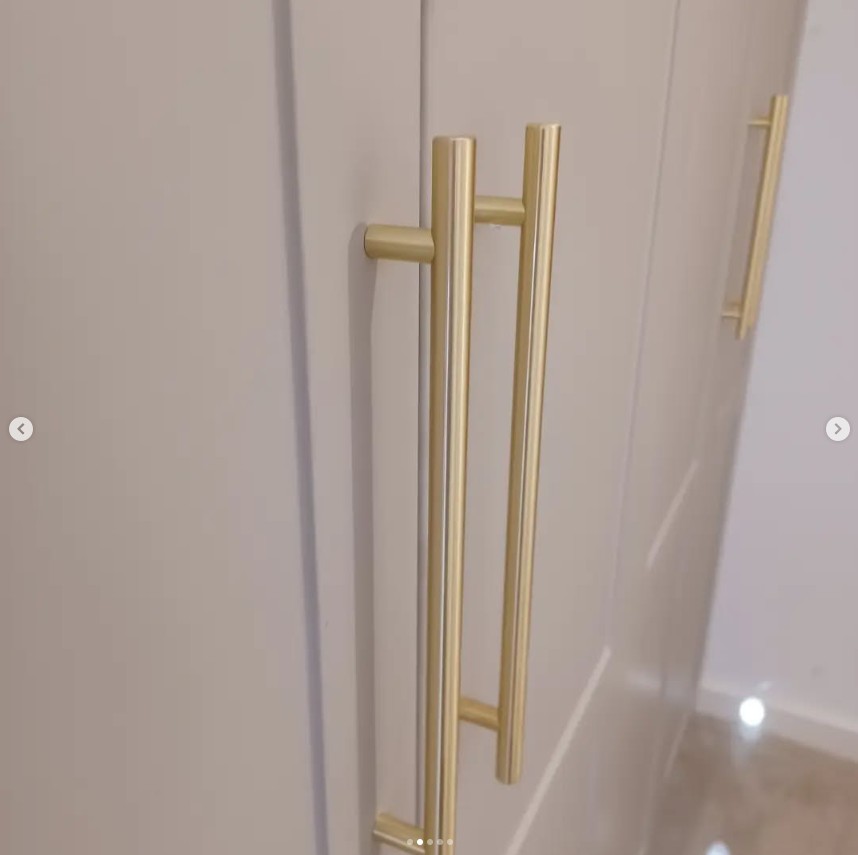 Detail of brass bar handles on fitted wardrobe doors