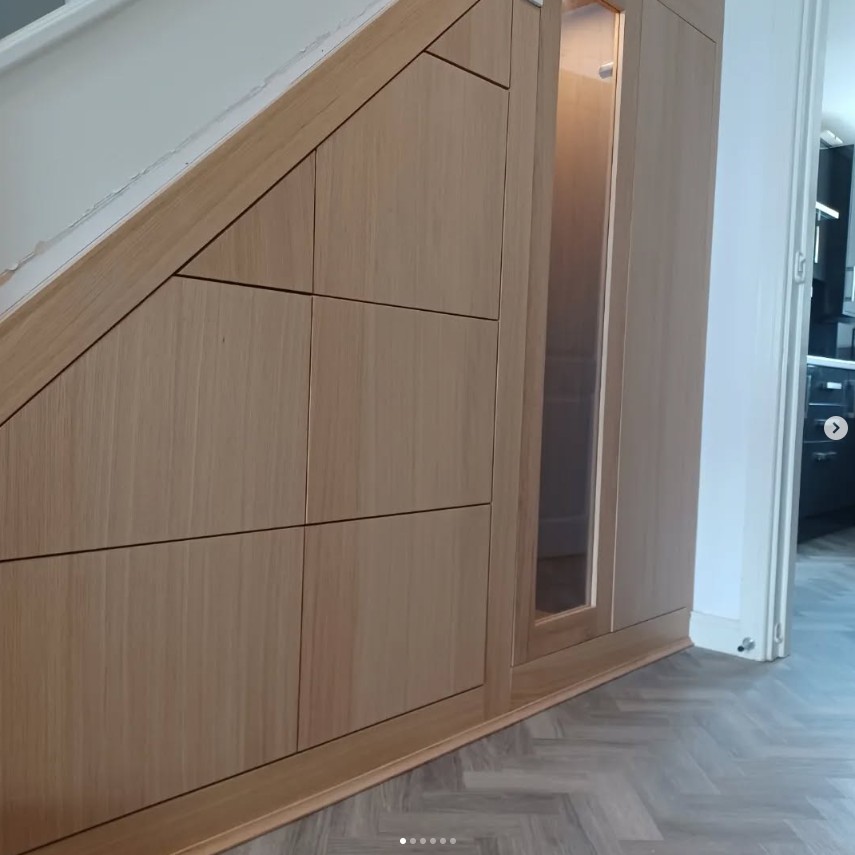 Natural oak under stairs storage with handleless design and integrated lighting
